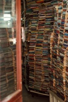 A neatly arranged pile of various books stacked on top of each other, showcasing colorful spines and diverse titles.