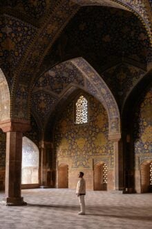 Man at Shah Mosque in Isfahan in Iran, looking at the decorative mosaic tile